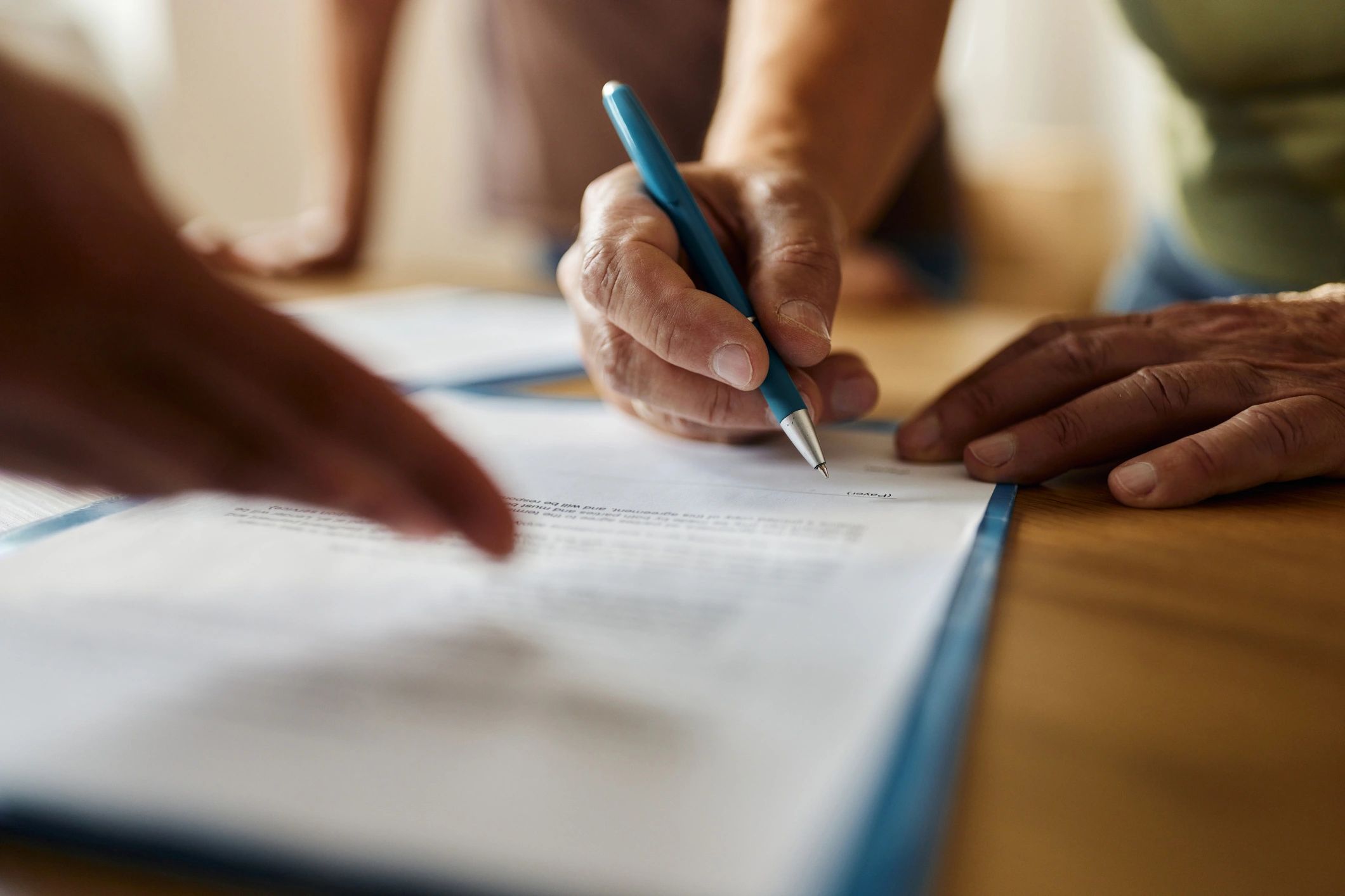 Close-up of someone signing real estate paperwork