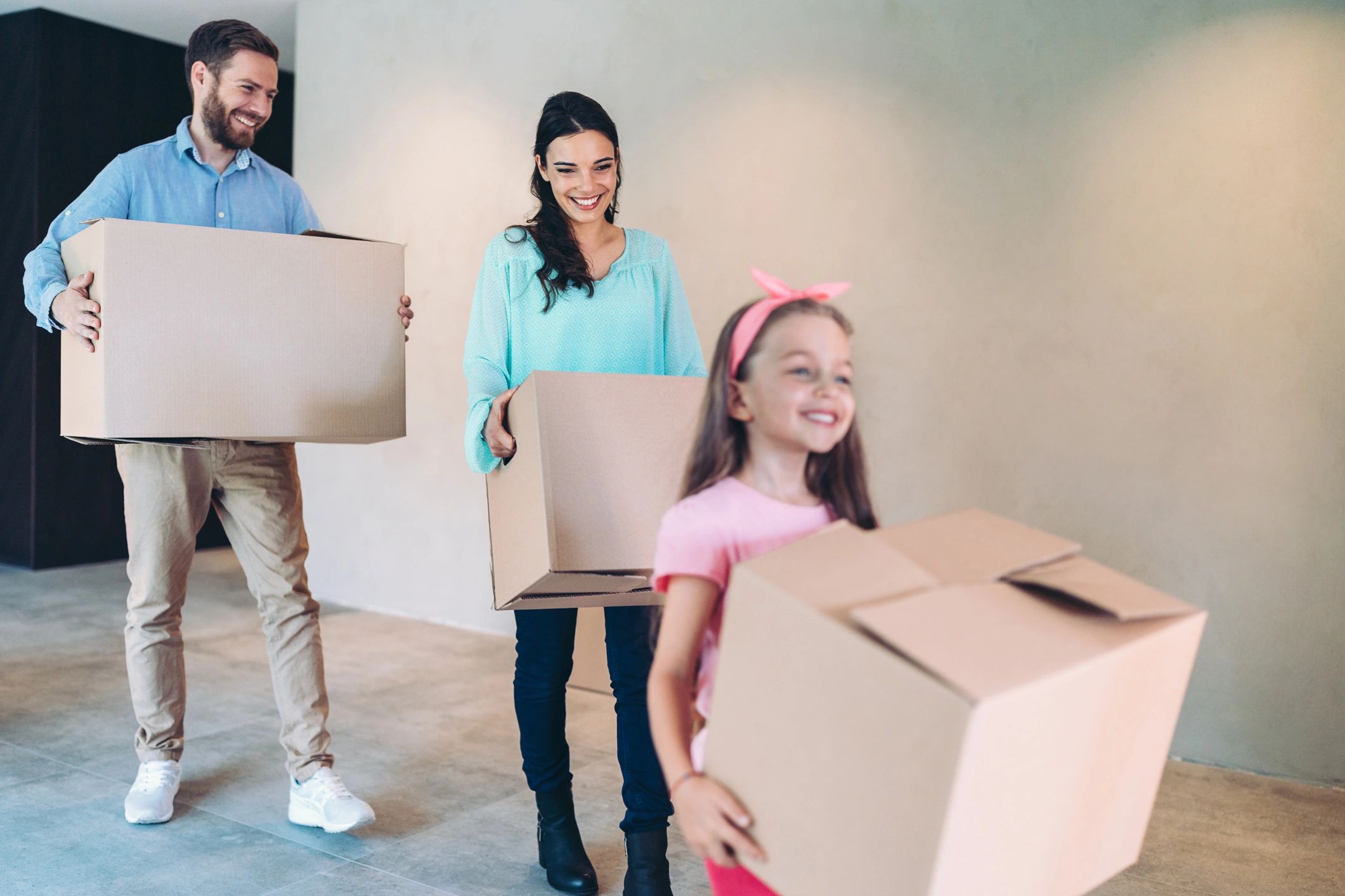 Happy family standing in a new home with moving boxes